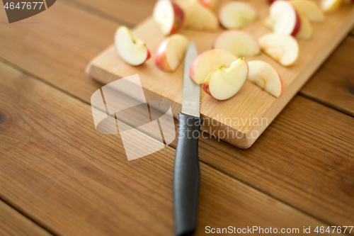 Image of sliced apples and knife on wooden cutting board