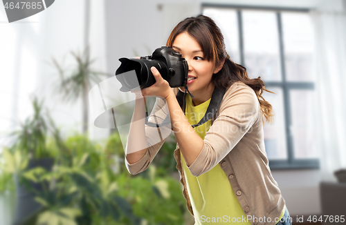 Image of asian female photographer with digital camera