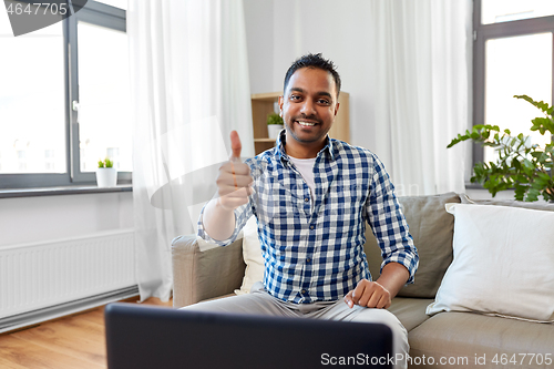 Image of indian male blogger showing thumbs up at home