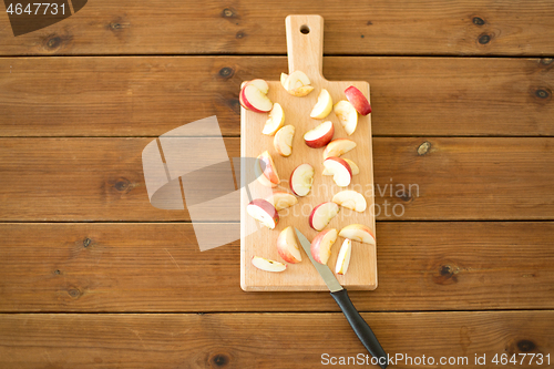 Image of sliced apples and knife on wooden cutting board