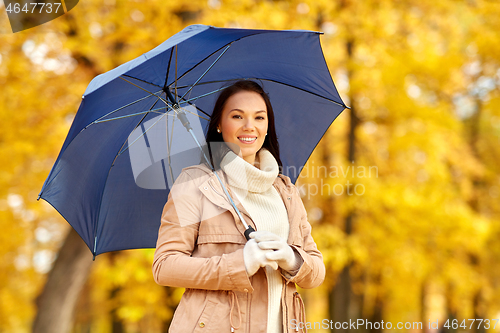 Image of happy woman with umbrella in autumn park