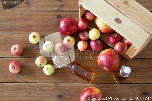 Image of bottles of apple juice or vinegar on wooden table