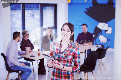 Image of portrait of young business woman at office with team in backgrou