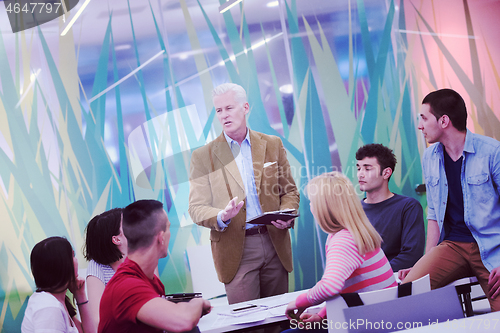 Image of teacher with a group of students in classroom