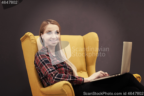 Image of startup business, woman  working on laptop and sitting on yellow