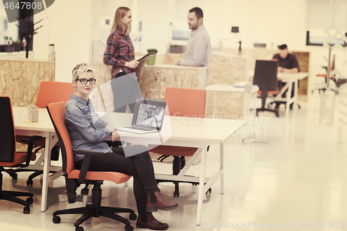 Image of portrait of young business woman at office with team in backgrou