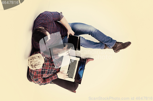 Image of top view of  couple working on laptop computer at startup office