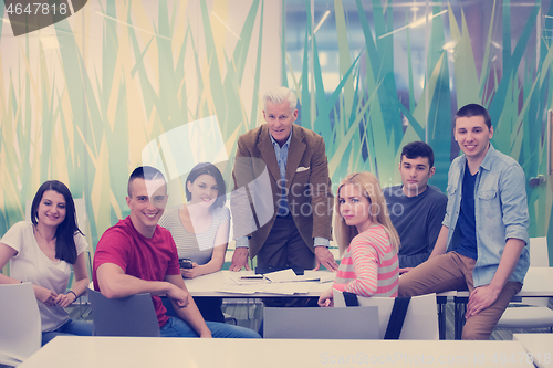 Image of portrait of  teacher with students group in background