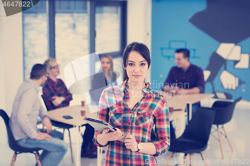 Image of portrait of young business woman at office with team in backgrou