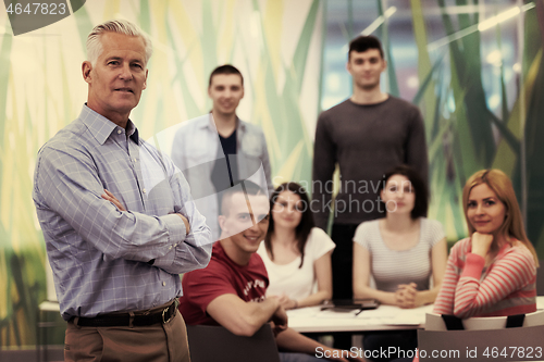 Image of portrait of  teacher with students group in background