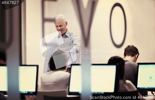 Image of teacher and students in computer lab classroom