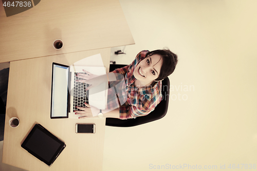 Image of top view of young business woman working on laptop