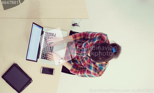 Image of top view of young business woman working on laptop