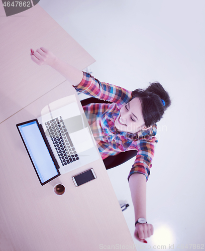 Image of top view of young business woman working on laptop