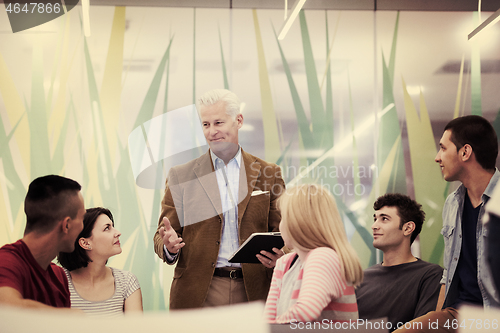 Image of teacher with a group of students in classroom