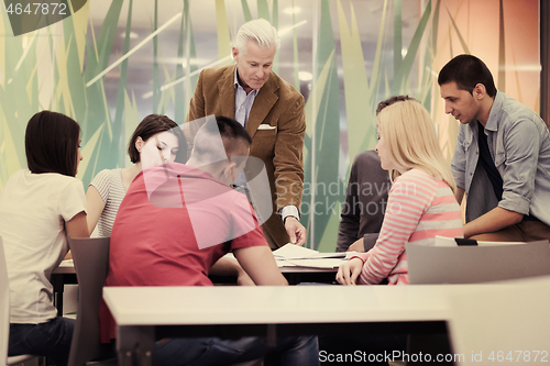 Image of teacher with a group of students in classroom