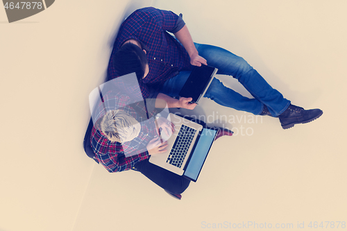 Image of top view of  couple working on laptop computer at startup office