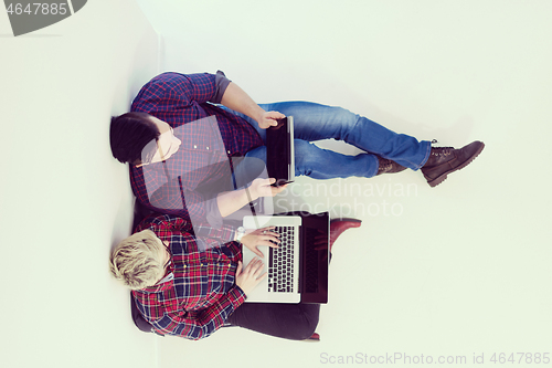 Image of top view of  couple working on laptop computer at startup office