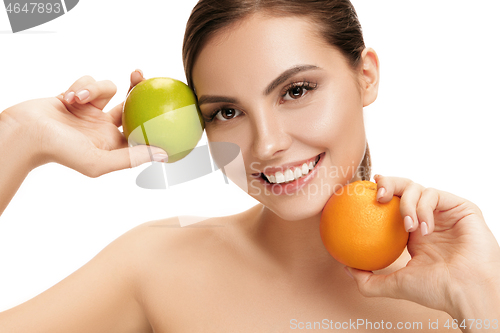 Image of portrait of attractive caucasian smiling woman isolated on white studio shot eating green apple