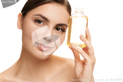 Image of Beauty concept. The pretty woman with perfect skin holding oil bottle