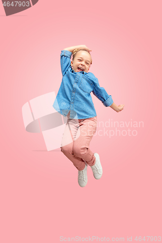 Image of Young happy caucasian teen girl jumping in the air, isolated on pink studio background.