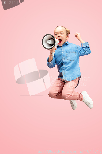 Image of Beautiful young child teen girl jumping with megaphone isolated over pink background