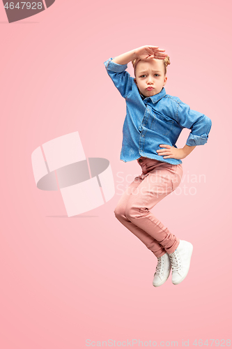 Image of Young happy caucasian teen girl jumping in the air, isolated on pink studio background.