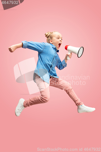 Image of Beautiful young child teen girl jumping with megaphone isolated over pink background