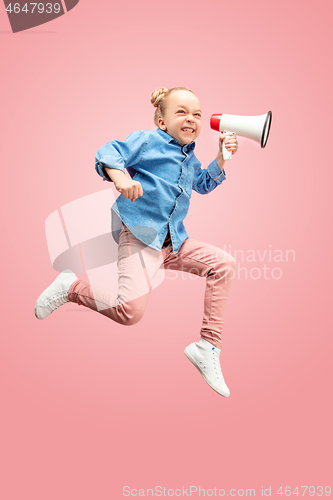 Image of Beautiful young child teen girl jumping with megaphone isolated over pink background