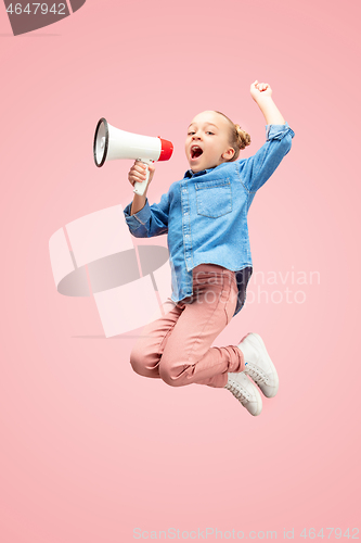 Image of Beautiful young child teen girl jumping with megaphone isolated over pink background