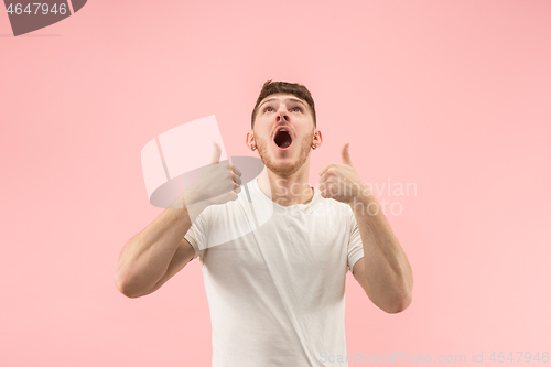 Image of The happy businessman standing and smiling against pink background.