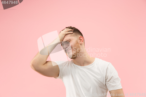 Image of Man having headache. Isolated over pink background.