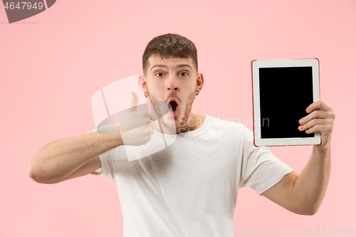 Image of portrait of smiling man pointing at laptop with blank screen isolated on white