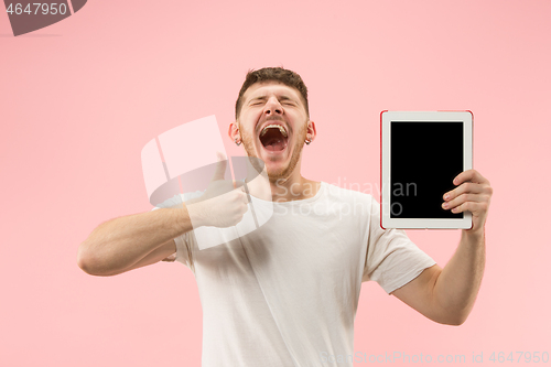 Image of portrait of smiling man pointing at laptop with blank screen isolated on white