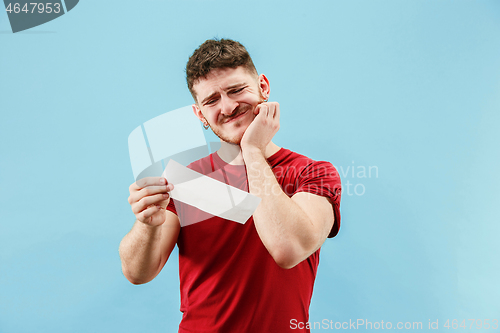 Image of Young boy with a surprised expression bet slip on blue background