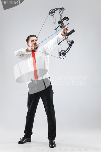 Image of Businessman aiming at target with bow and arrow, isolated on white background