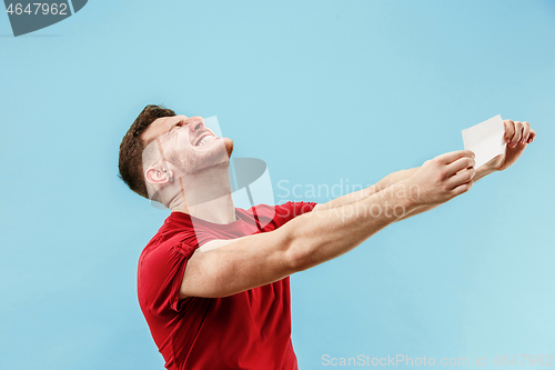 Image of Young boy with a surprised expression bet slip on blue background