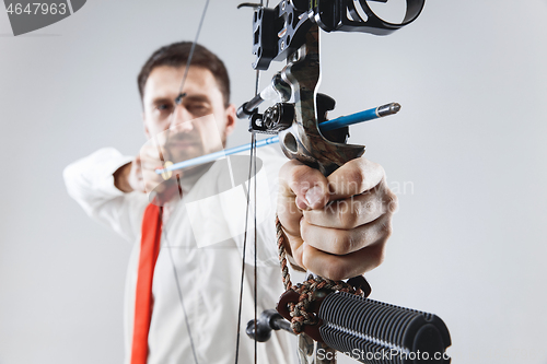 Image of Businessman aiming at target with bow and arrow, isolated on white background