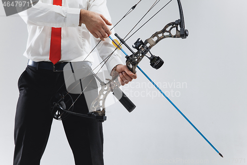 Image of Businessman aiming at target with bow and arrow, isolated on white background