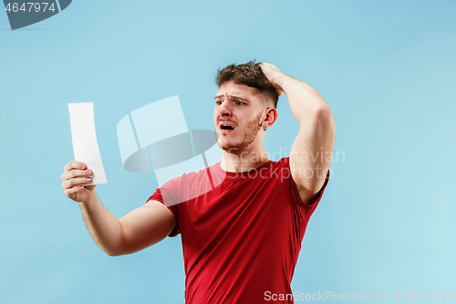 Image of Young boy with a surprised expression bet slip on blue background