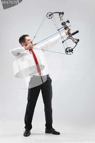 Image of Businessman aiming at target with bow and arrow, isolated on white background