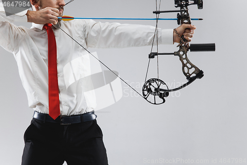 Image of Businessman aiming at target with bow and arrow, isolated on white background