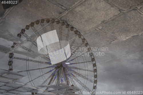 Image of Reflection of a Ferris Wheel in Puddle on Sidewalk of Paris, France