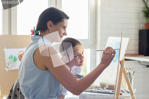 Image of Drawing teacher shows girl how to draw