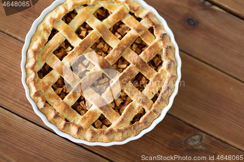 Image of close up of apple pie in mold on wooden table