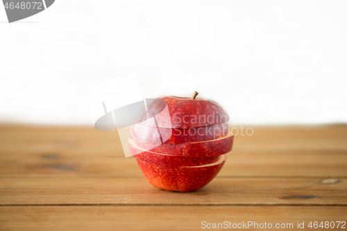 Image of sliced red apple on wooden table