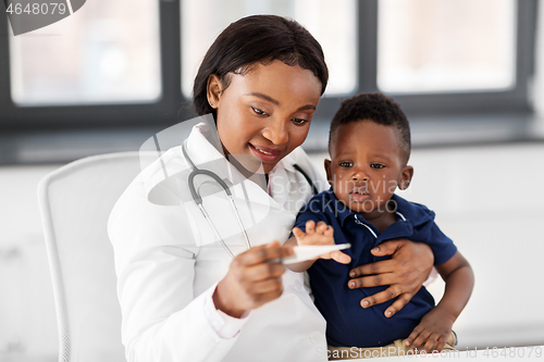 Image of doctor with measuring baby\'s temperature at clinic