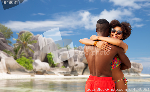Image of african american couple hugging on summer beach