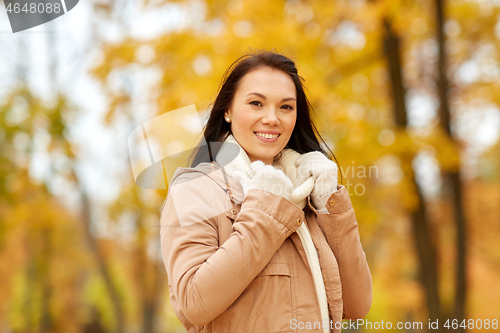 Image of beautiful happy young woman smiling in autumn park