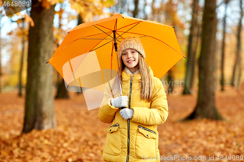 Image of happy girl with umbrella at autumn park